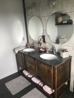 a bathroom with two sinks and mirrors on the wall