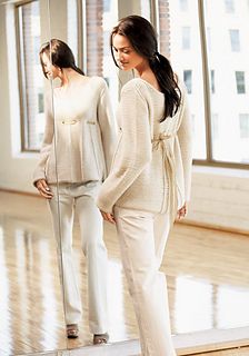 two women standing in front of a mirror wearing sweaters and pants with heels on the floor