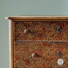 the drawers are decorated with an intricate pattern and metal knobs on each one side