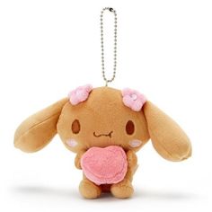 a small stuffed animal with a pink heart in its mouth