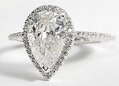 a pear shaped diamond engagement ring on a white background