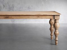 an old wooden table sitting on top of a cement floor