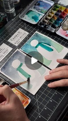 someone is painting letters with watercolors on paper