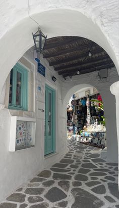 an archway leading to a store with blue doors and windows on the side of it