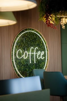 there is a coffee sign on the wall in front of some blue chairs and tables