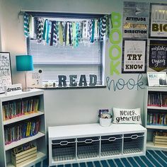 a room filled with lots of books on shelves next to a window covered in posters