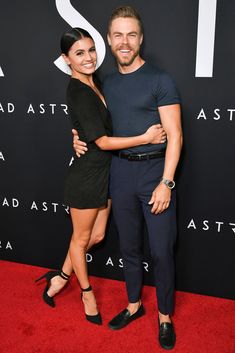 a man and woman standing next to each other on a red carpet at an event