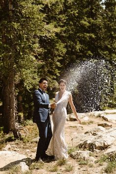 a bride and groom are throwing water on each other