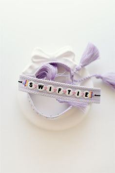 a white ribbon with the word swiptife on it sitting next to a spool of thread