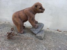 a teddy bear standing on top of a rock