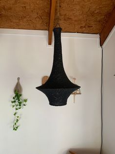 a black chandelier hanging from the ceiling next to a wooden chair and table