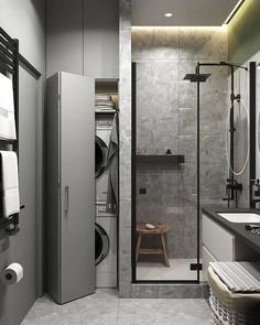 a bathroom with a walk in shower next to a sink and a washer dryer