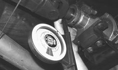 a black and white photo of a person holding a wrench next to a water pump