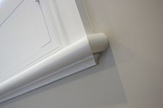 the corner of a white door with a handle on it's left hand side