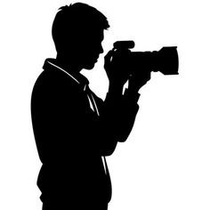 a man in a suit holding a camera and taking pictures with his cell phone silhouetted against