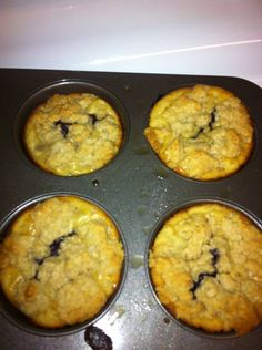 four blueberry muffins in a pan ready to be baked