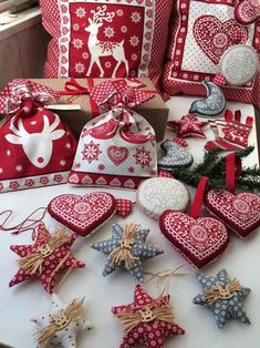 red and white christmas decorations are on the table with other items in front of them