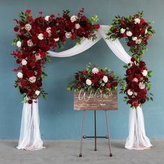 a wedding arch decorated with red and white flowers