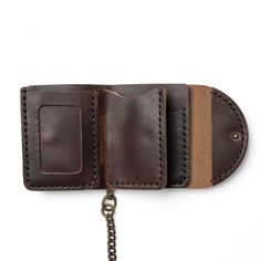 a brown leather wallet with a metal chain hanging from it's front pocket on a white background