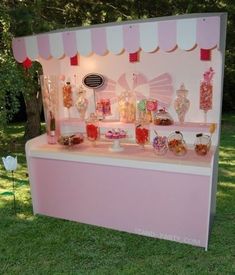 a pink candy bar with lots of candies and lollipops