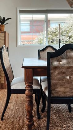 a dining room table and chairs in front of a window