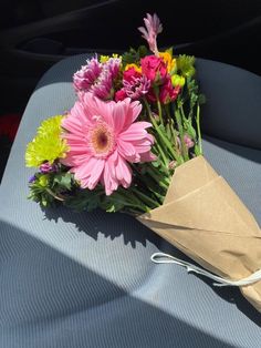 a bouquet of flowers sitting on top of a car seat