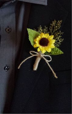 a boutonniere with a sunflower attached to the lapel of a suit