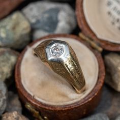 a ring with a diamond in it sitting on some rocks