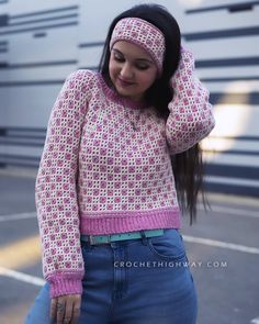 a woman wearing a pink sweater and headband