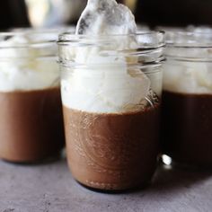 three jars filled with chocolate pudding and whipped cream