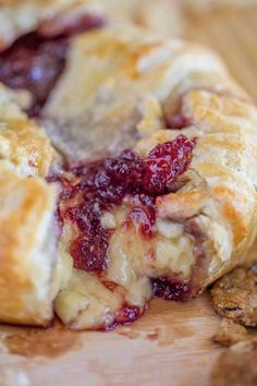 a close up of a pastry with cranberry sauce on it next to crackers