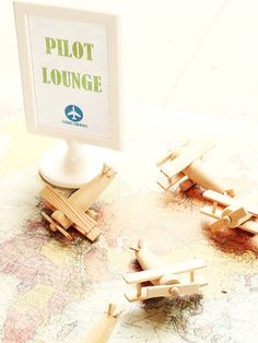 there is a lot of wooden airplanes on top of the world map with a sign that says pilot lounge