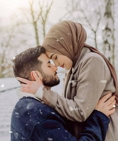 a man and woman kissing in the snow