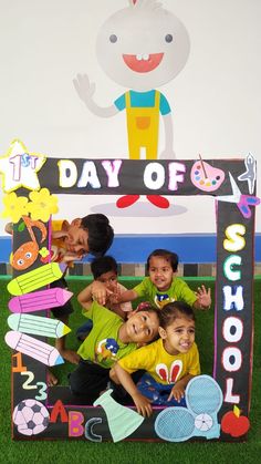 a group of children posing for a photo in front of a day of school sign