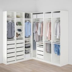 a white closet with clothes and shoes on it's shelves next to a wooden floor