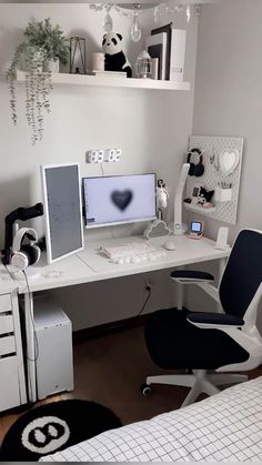 a white desk topped with two computer monitors and a laptop next to a bed in a room