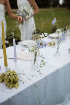 the table is set with flowers, candles and wine glasses for an outdoor wedding reception