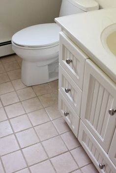 a white toilet sitting next to a sink in a bathroom