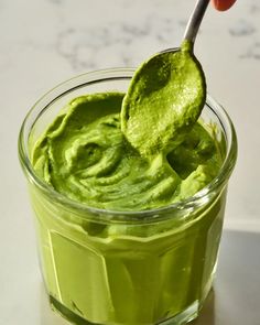 a spoon full of green guacamole on a table