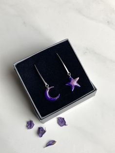 Stunning Moon and Star long dangle earrings. Special gift for many occasions. I take my inspiration from Scotland's nature, skies and seas and all things celestial. This design evokes deep calm and the mysticism of the sky at night. Each moon and star is individually hand painted with love and care. Once dry, I apply resin to protect the paint and to give a glassy effect.  Note that each painted moon and star is slightly different due to the application and setting of the paints; this adds to the uniqueness of the jewellery. The earring hooks and moon and star are all made of 925 sterling silver. The rubber back fasteners are hypoallergenic. The moon and star both measure 1.5 cm and the long earring hooks give a drop of 4.3cm when worn. The earrings come in a small grey gift box. A complem Scotland Nature, Painted Moon, The Sky At Night, Sky At Night, Long Earring, Sky Design, Purple Design, Moon And Star, Long Dangle Earrings