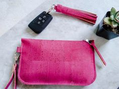 This bright hot pink wristlet is a simple accessory that will add life to your outfit. The quality cork is soft and eco-friendly. It's the perfect little bag for special occasions such as weddings and proms. Make it a set and save 10% with the option to add a matching purse charm (tassel). Our chic cork leather wristlet is a stylish, eco-friendly bag perfectly sized for carrying your cash, cards and phone. Remove the wrist strap and use as a zip pouch inside another bag to organize small essentials. Use the cork leather charm (tassel) to adorn your key ring or clip it to another bag for a pop of color. SMALL: 7 inches wide, 4.5 inches high LARGE: 8.5 inches wide, 5 inches high Our beautiful, durable cork leather accessories are offered in many different colors and patterns. See more here: Cork Clutch, Cork Bag, Vegan Purses, Pink Wristlet, Zip Wallet, Purse Charms, Leather Wristlet, Zip Pouch, Wrist Strap