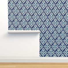 a wall with a blue and white flower pattern on it, next to a wooden floor