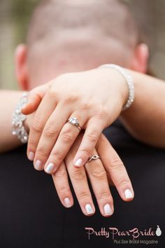 a man and woman holding each other's hands with wedding rings on their fingers