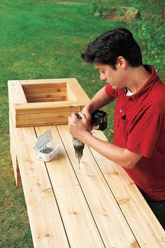 a man sanding wood with a drill and screwdriver on a picnic table