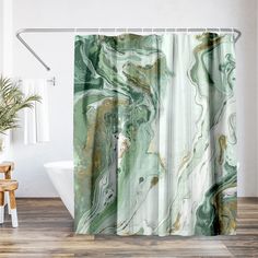 a shower curtain with green and gold marble pattern on it, next to a white bath tub