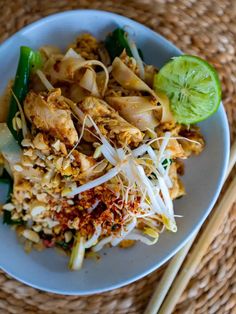 a white plate topped with food next to chopsticks on top of a table