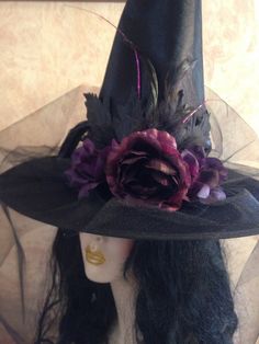 a black hat with purple flowers and feathers