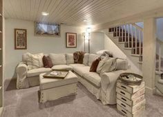 a living room filled with furniture next to a stair case