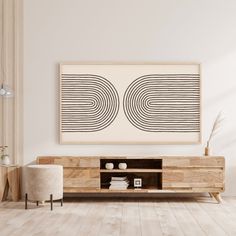 a living room scene with focus on the entertainment center and art hanging over the tv