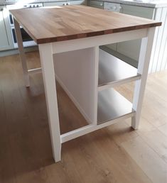 a kitchen island made out of wood and white cabinets